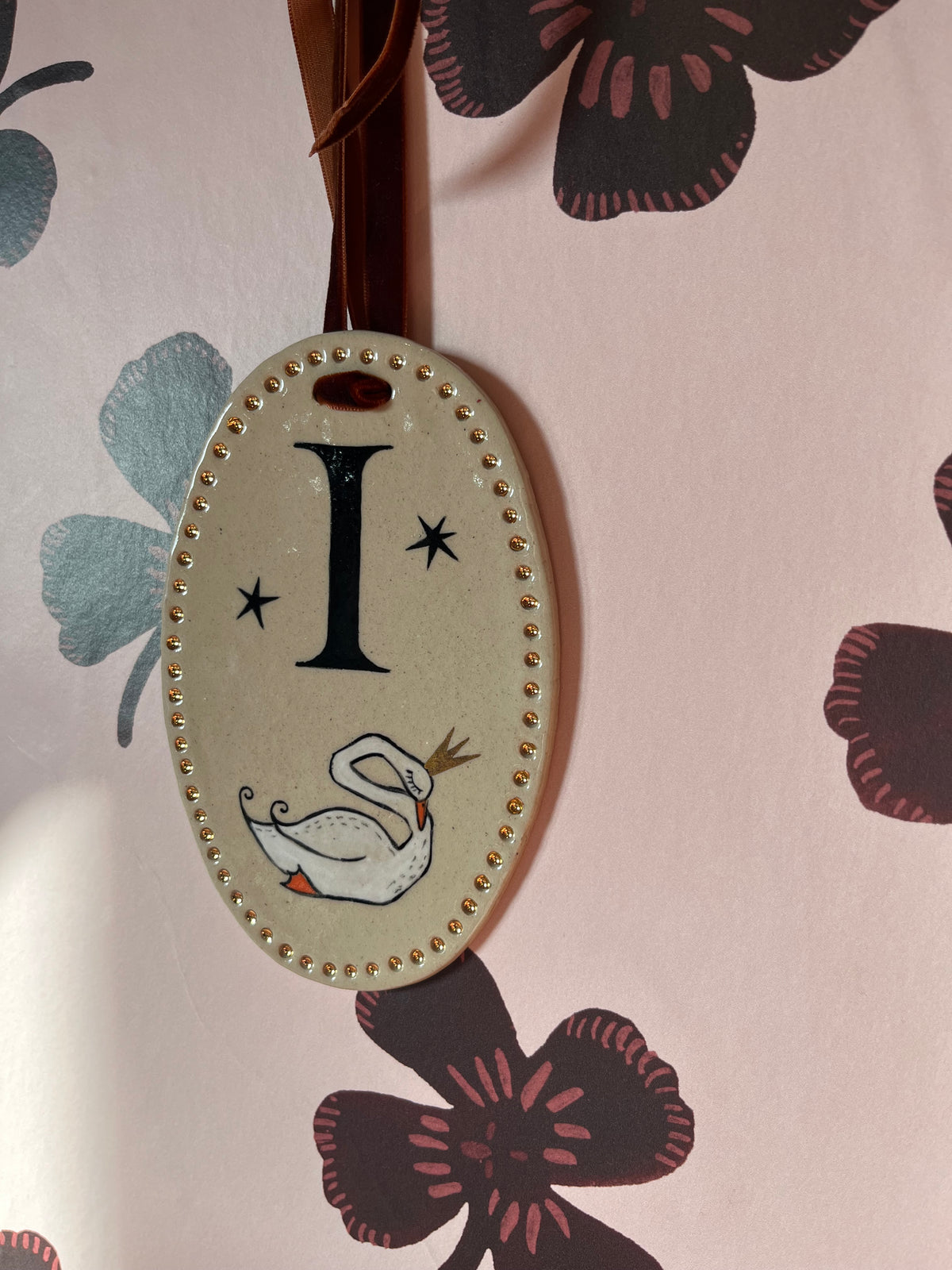 Detailopname van een handgemaakt letterbordje met letter en dierillustratie bij sfeervol licht