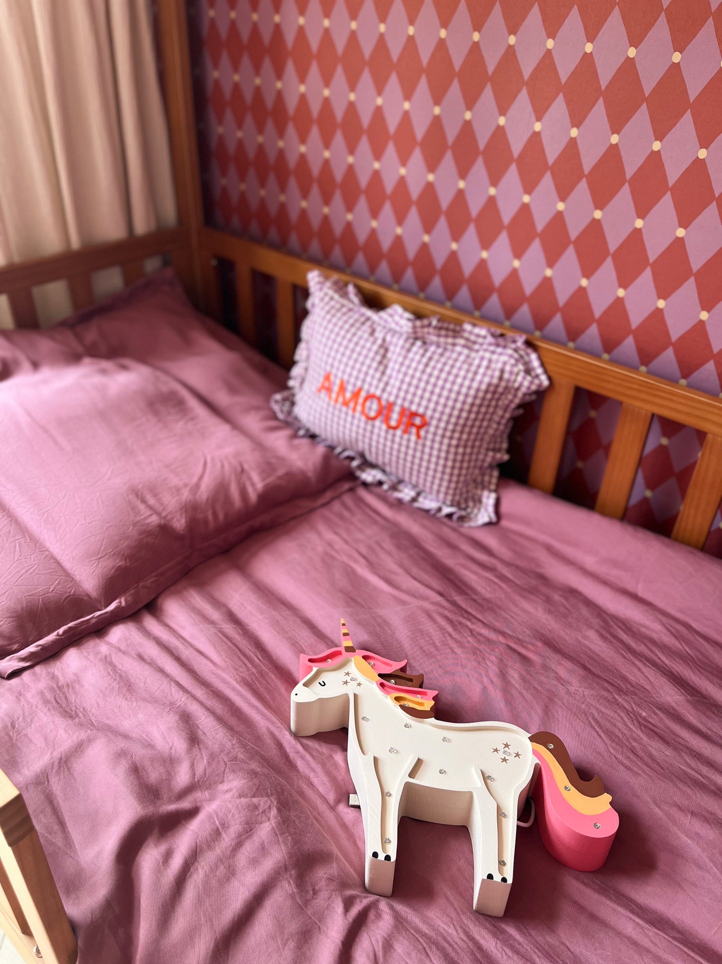 Sfeervolle meisjeskamer met een houten bedstee en roze rood harlekijn behang op de achterwand.