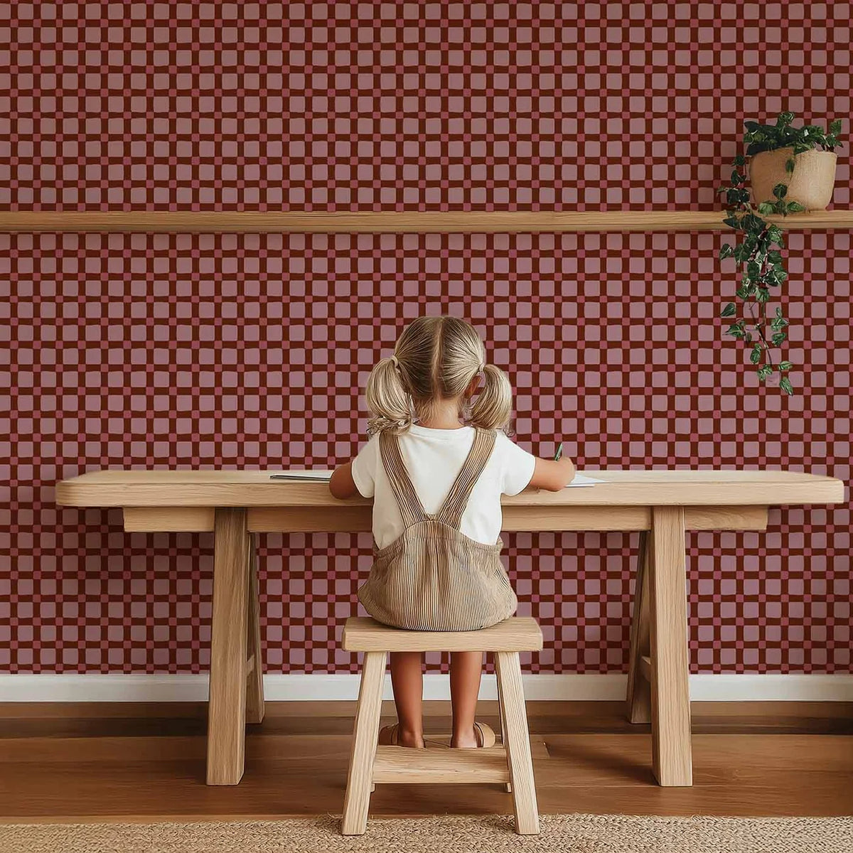 Sfeervolle kinderkamer wand met Atelier Chien Geblokt quilt bordeauxrood behang achter houten speeltafel