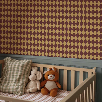 Knusse babykamer met een houten ledikant, knuffels en een bordeaux okergeel harlekijn vliesbehang van Atelier Chien