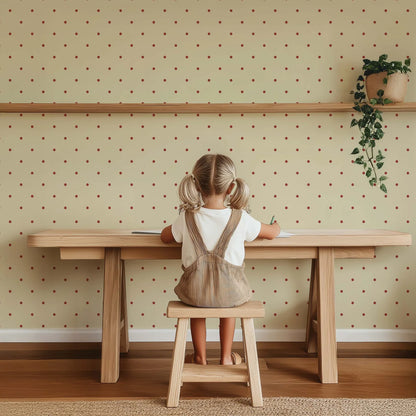 Kinderkamer wand met Atelier Chien Polkadot mini wijnrood behang achter houten bureau en stoeltje