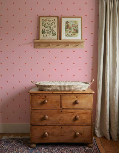 Kinderkamer wand met Atelier Chien Polkadot maxi roze rood behang achter houten commode en wandplankje