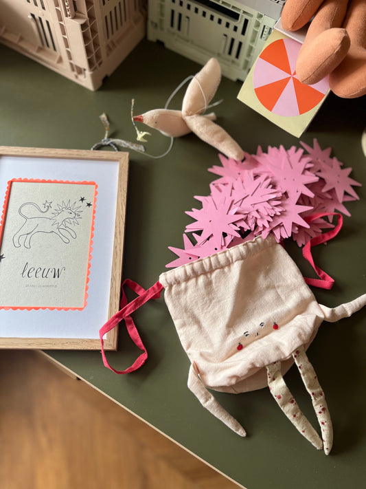 Atelier Fabel sterrenbeeld poster Leeuw ingelijst op een groene tafel naast decoratieve kinderkamer accessoires