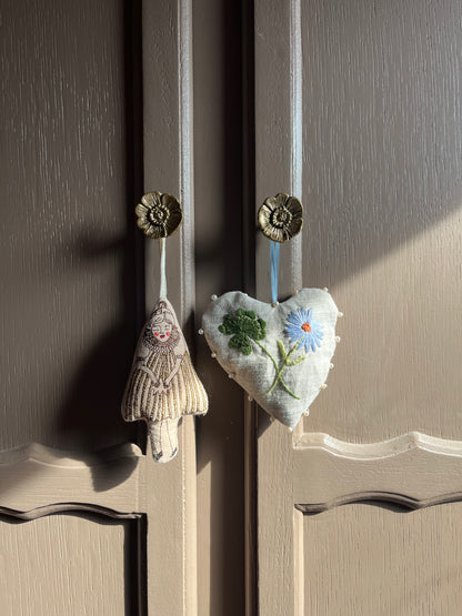 Detailfoto van de handgeborduurde bloemen en gepersonaliseerde details op de muurhanger