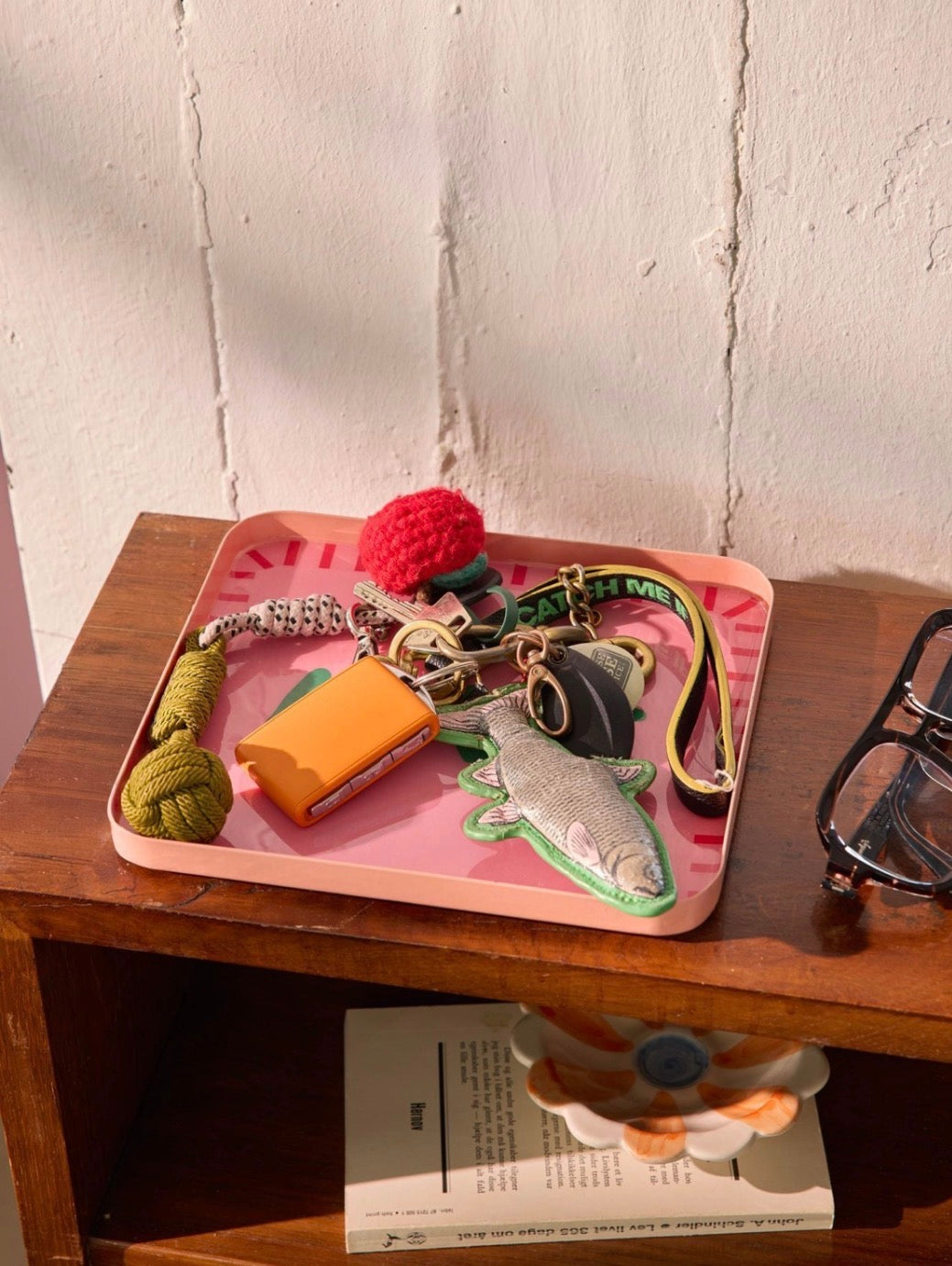 Rice roze metalen serveerschaal Love op een houten kastje gevuld met sleutels en accessoires